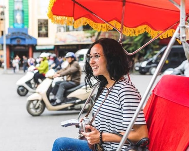 Seorang wanita menggunakan kendaraan tradisional saat solo traveling Foto: Dok. Booking.com