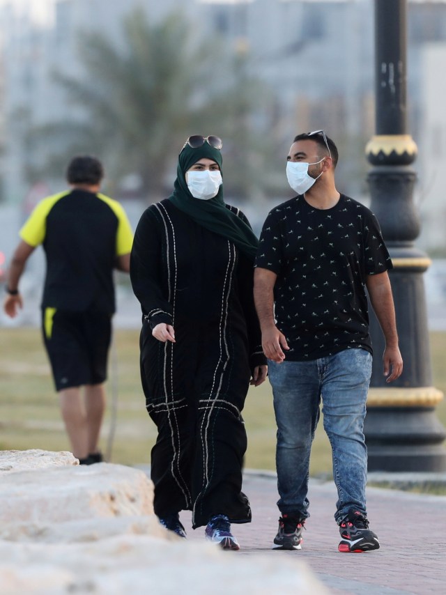 Sejumlah pejalan kaki mengenakan masker di provinsi Qatif, Arab Saudi. Foto: REUTERS