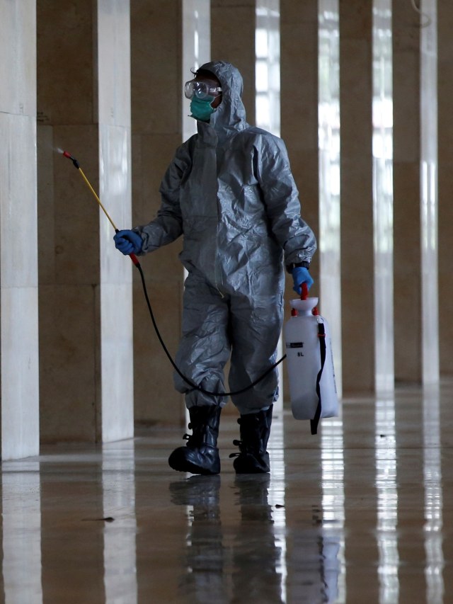 Petugas medis menyemprotkan cairan disinfektan di area Masjid Istiqlal, Jakarta Pusat, Jumat (13/3).  Foto: REUTERS / Willy Kurniawan