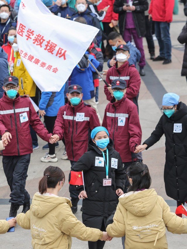 Sejumlah staf medis merayakan setelah pasien virus corona dipulangkan ke rumah dari Rumah Sakit Sementara di Wuhan, Hubei, China. Foto: AFP/STR