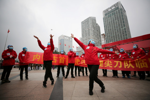 Staf medis menggelar perayaan setelah pasien corona dipulangkan ke rumah dari Rumah Sakit Sementara di Wuhan, Hubei, China. Foto: AFP/STR