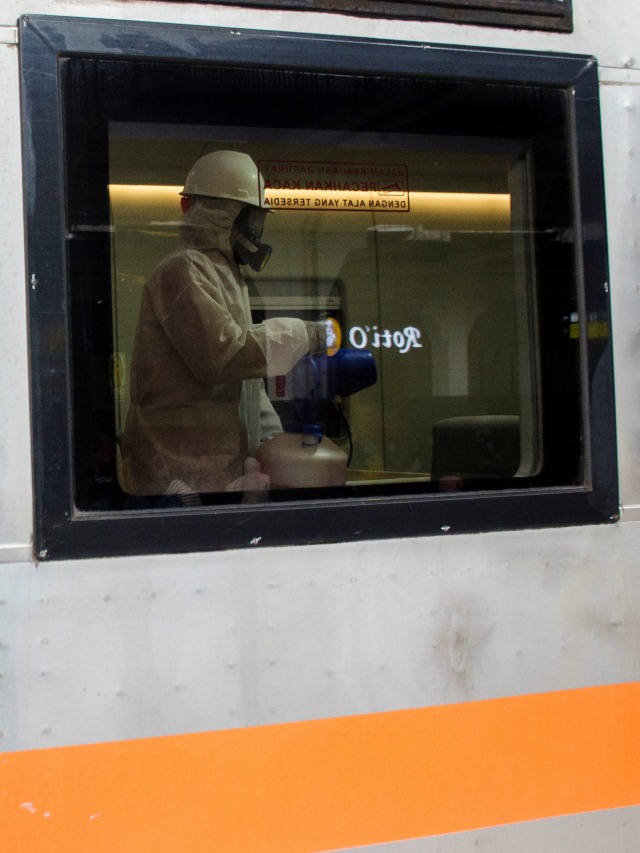 Petugas menyemprotkan cairan disinfektan pada gerbong Kereta Argo Parahyangan di Stasiun Bandung, Jawa Barat, Minggu (15/3). Foto: ANTARA FOTO/Novrian Arbi