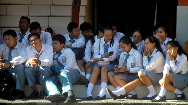 Sejumlah siswa menyimak pengarahan ditundanya pelaksanaan Ujian Nasional Berbasis Komputer (UNBK) di SMK Pariwisata Dalung, Badung, Bali, Senin (16/3/2020). Foto: Fikri Yusuf