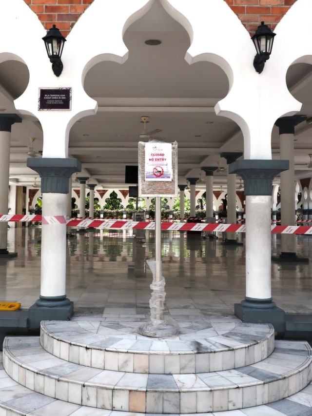Sebuah tanda mengumumkan penutupan masjid karena operasi desinfeksi untuk wabah coronavirus di Kuala Lumpur, Malaysia, Senin (16/3). Foto: REUTERS/Lim Huey Teng