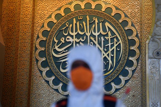 Petugas Badan Penanggulangan Bencana Daerah (BPBD) Jatim menyemprotkan cairan disinfektan di Masjid Nasional Al Akbar Surabaya, Jawa Timur, Selasa (17/3). Foto: ANTARA FOTO/Zabur Karuru