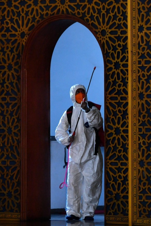 Petugas Badan Penanggulangan Bencana Daerah (BPBD) Jatim menyemprotkan cairan disinfektan di Masjid Nasional Al Akbar Surabaya, Jawa Timur, Selasa (17/3). Foto: ANTARA FOTO/Zabur Karuru