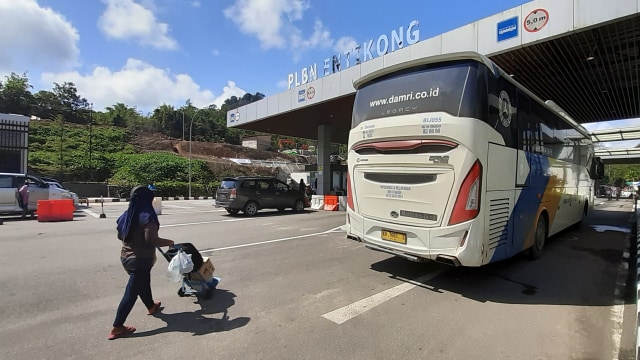 Seorang pelintas batas yang masuk dari Malaysia mendorong tas bawaannya di Pos Lintas Batas Negara (PLBN) Entikong di Kabupaten Sanggau, Kalimantan Barat. Foto: ANTARA FOTO/Agus Alfian