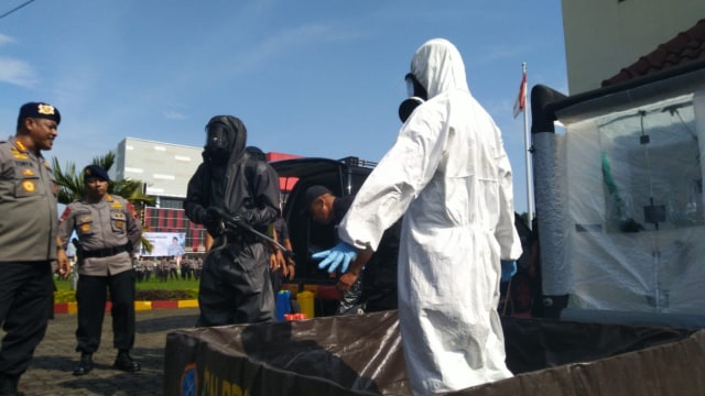 Simulasi seorang petugas mengenakan Hazmat disemprot desinfektan setelah melakukan pembersihan atau penyemprotan desinfektan, Semarang, Rabu (18/3). Foto: Afiati Tsalitsati/kumparan