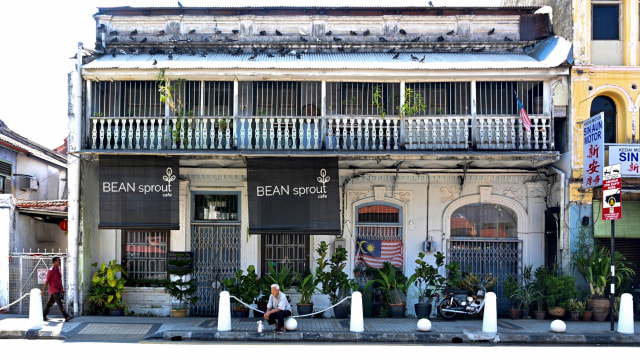 Warga sedang istirahat di dekat restoran yang tutup di Malaysia, Rabu (18/3). Foto: AFP/GOH CHAI HIN