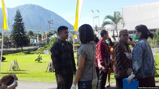 Pemeriksaan suhu tubuh kepada umat yang hendak memasuki gedung gereja Katedral Ruteng, Nusa Tenggara Timur pada saat upacara penahbisan Uskup Ruteng, Kamis, 19 Maret 2020. ( Foto: Pastor Steven Lalu)