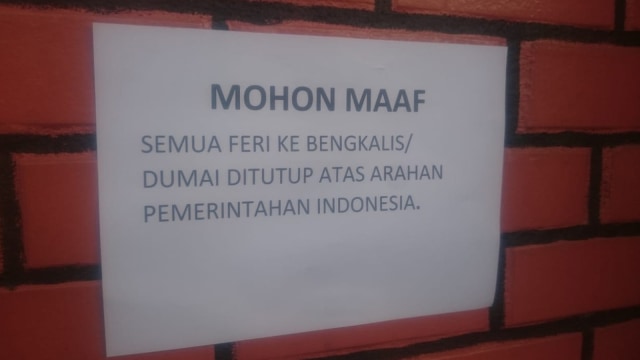 PENGUMUMAN ditempelkan pihak terkait di Pelabuhan Muar, Johor, Malaysia, usai kedua pemerintah menerapkan lockdown, Sabtu, 21 Maret 2020. 
