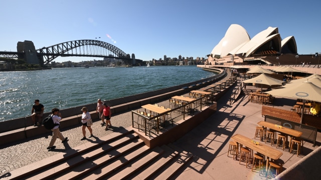 Sejumlah turis berjalan di kawasan Circular Quay, Sydney, Australia. Foto: AFP/PETER PARKS