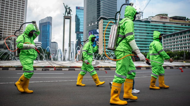 Petugas bersiap menyemprotkan cairan disinfektan di kawasan Bundaran HI, jakarta. Foto: ANTARA FOTO/Aprillio Akbar