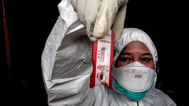 Petugas Dinas Kesehatan Kabupaten Bogor menunjukkan hasil tes cepat (rapid test) pendektesian COVID-19 kepada orang dalam pengawasan (ODP) di Bogor. Foto: ANTARA FOTO/Yulius Satria Wijaya