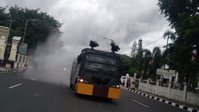 Water canon menyemprotkan cairan desinfektan di ruas jalan utama Kota Padang. Foto: Irwanda/langkan.id 