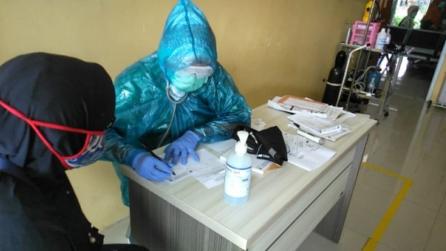 Petugas Skrining Orang Dalam Pantauan (ODP) di Bogor pakai jas hujan. Foto: Dok. Istimewa