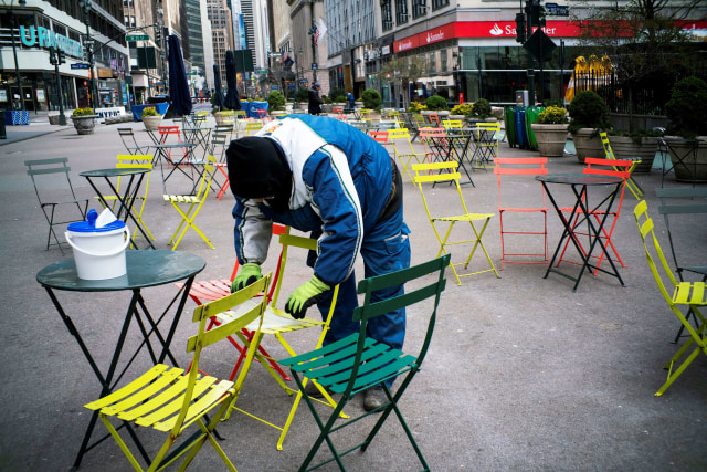 Pekerja membersihkan meja dan kursi di New York, Amerika Serikat saat kota tersebut sedang lockdown. Foto: REUTERS / Eduardo Munoz