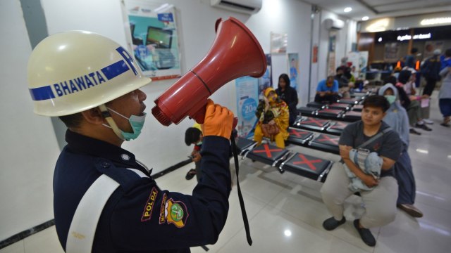 Petugas memberikan pengumuman kepada calon penumpang di Stasiun Pasar Senen, Jakarta, Senin (23/3). Foto: ANTARA FOTO/Aditya Pradana Putra