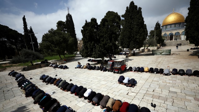 Umat muslim melaksanakan salat di depan Masjid Al-Aqsa yang ditutup antisipasi wabah virus corona di Yerusalem. Foto: REUTERS / Ammar Awad