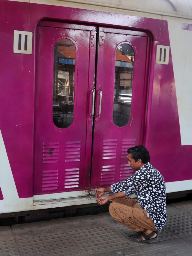 Petugas mengunci pintu kereta. Foto: AP/Rafiq Maqbool