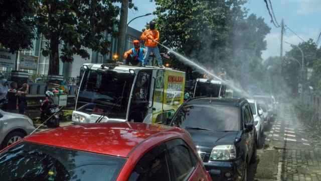Petugas melakukan penyemprotan di ruas jalan Kabupaten Bogor untuk cegah COVID-19. Foto: ANTARA FOTO/Yulius Satria Wijaya