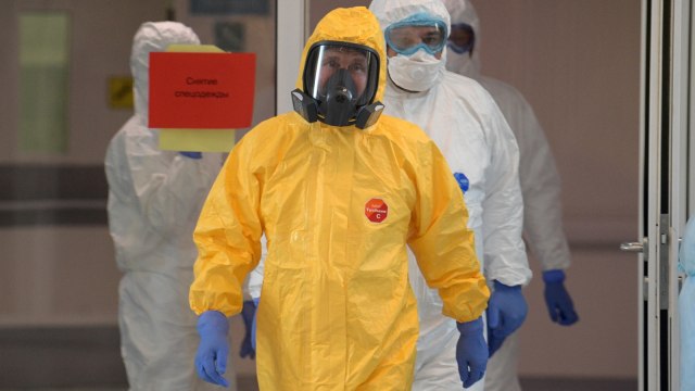 Presiden Rusia Vladimir Putin mengenakan pakaian Hazmat kuning saat menenui pasien corona di rumah sakit Kommunarka, Moskow, Rusia, Selasa (24/3). Foto: Alexey DRUZHININ / SPUTNIK / AFP