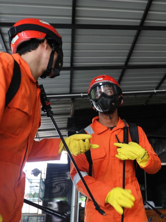 Dua petugas dari tim Dompet Dhuafa Aceh bersiap untuk menyemprot disinfektan di Posko Jurnalis Peliput COVID-19 di Banda Aceh, Rabu (25/3/2020). Foto: Suparta/acehkini