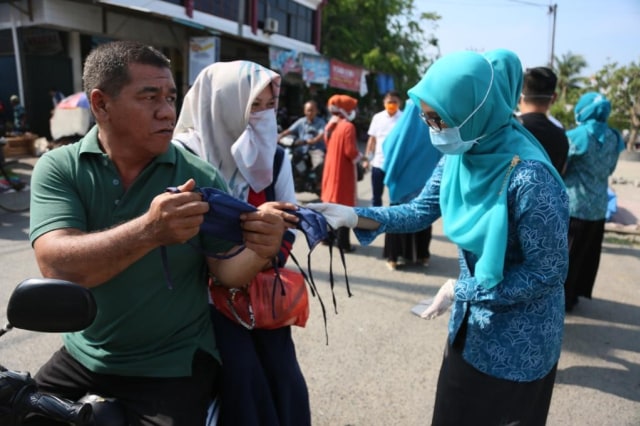 Tim PKK Aceh membagi masker untuk pengguna jalan di Aceh. Foto: Humas Aceh.