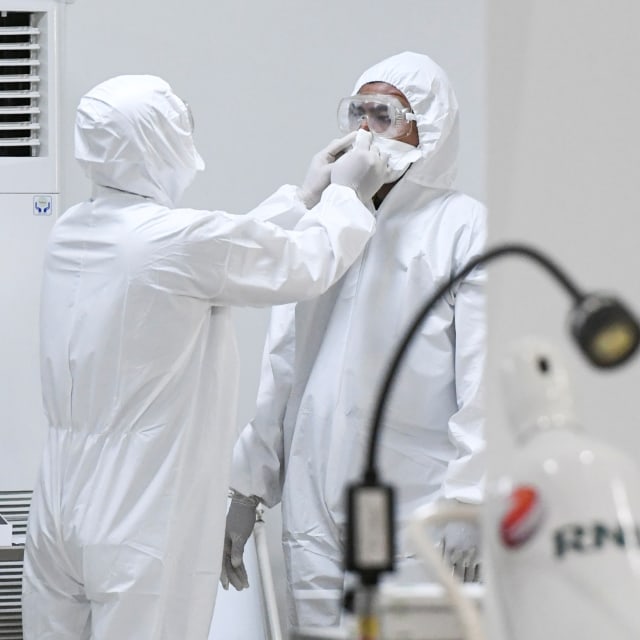 Petugas mengenakan alat kesehatan. Foto: ANTARA FOTO/Hafidz Mubarak A