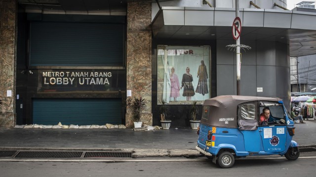 Warga beraktivitas di depan pintu masuk Pasar Tanah Abang yang tutup di Jakarta Foto: ANTARA FOTO/Aprillio Akbar