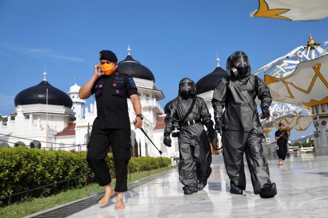Tim Gegana Polda Aceh menyemprot disinfektan di Masjid Raya Baiturrahman, Banda Aceh, pada Jumat (20/3/2020). Foto: Suparta/acehkini 