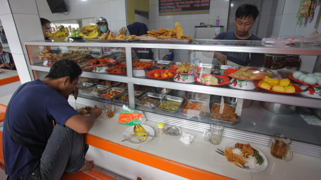 Pedagang melayani pembeli di Warteg Subsidi Bahari kawasan Jalan Fatmawati, Jakarta. Foto: ANTARA FOTO/Reno Esnir