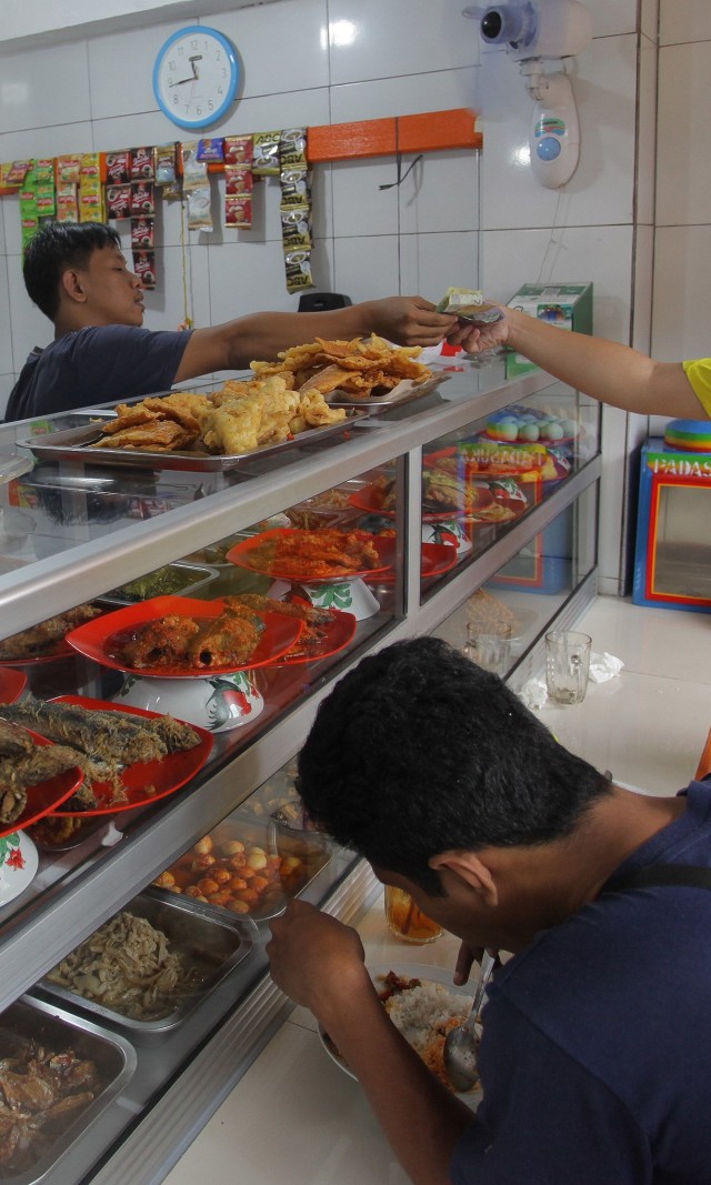 Pedagang melayani pembeli di Warteg Subsidi Bahari kawasan Jalan Fatmawati, Jakarta. Foto: ANTARA FOTO/Reno Esnir