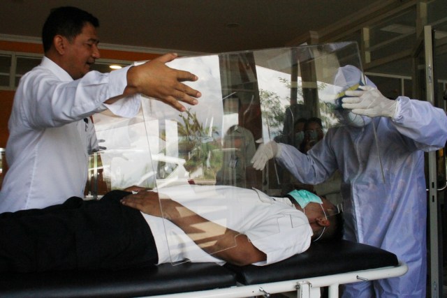 Petugas medis memperagakan penggunaan bilik pengaman hasil inovasi tim pengajar dan mahasiswa, Universitas Muhammadiyah Malang, Jawa Timur, Senin (30/3). Foto: ANTARA FOTO/Ari Bowo Sucipto