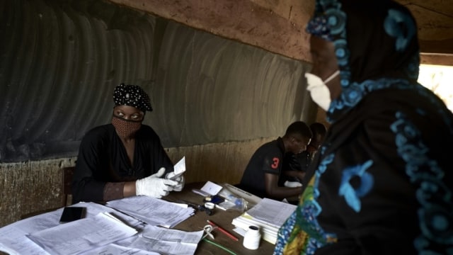 Warga menggunakan masker saat mengikuti parlemen di Mali. Foto: AFP / MICHELE CATTANI