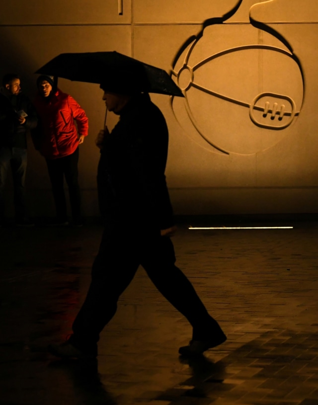 Seorang pria berjalan melewati logo Tottenham Hotspur. Foto: Reuters/Dylan Martinez