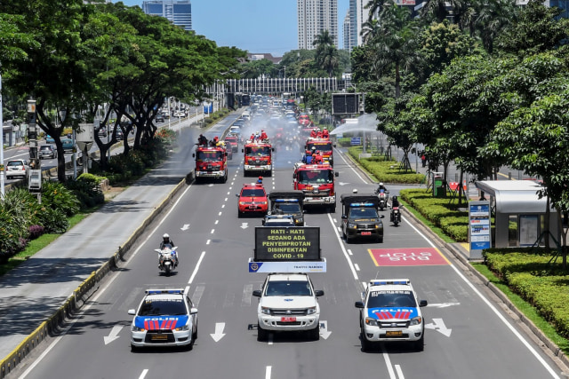 Petugas gabungan menyemprotkan cairan disinfektan di sepanjang jalan Jenderal Sudirman-MH Thamrin, Jakarta, Selasa (31/3). Foto: ANTARA FOTO/Muhammad Adimaja