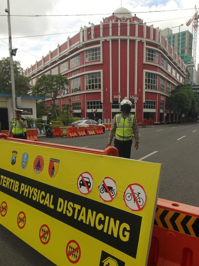 Polisi berjaga di kawasan tertib physical distancing di Jalan Tunjungan, Surabaya, Jawa Timur. Foto: ANTARA FOTO/Didik Suhartono