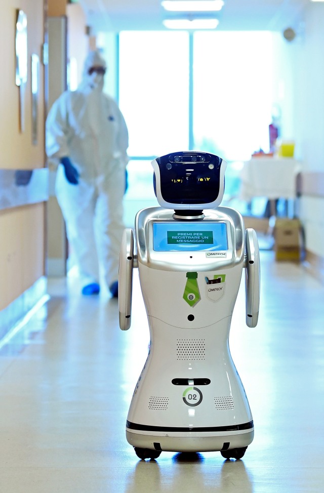 Sebuah robot yang membantu tim medis merawat pasien virus corona di rumah sakit Circolo, Varase, Italia.
Foto: REUTERS / Flavio Lo Scalzo