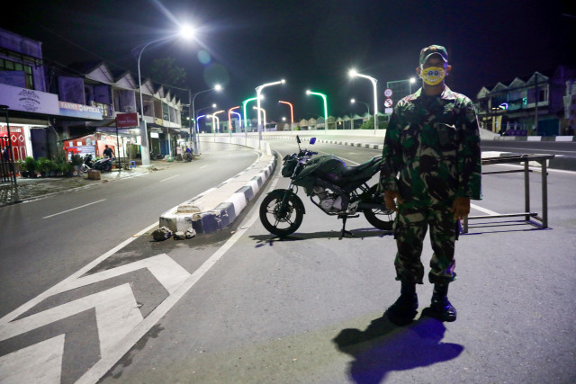 TNI bermasker kuning menjaga jam malam di pintu masuk jembatan flyover, Banda Aceh. Foto: Suparta/acehkini 