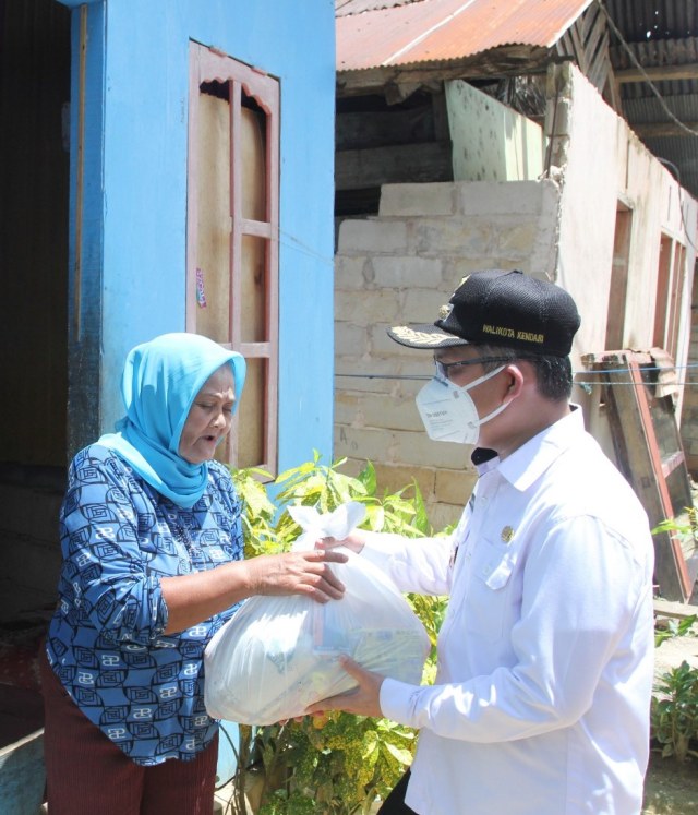 Walikota Kendari, Ir Sulkarnain menyerahkan bantuan paket sembako kepada warga. Foto: Dok Pemkot Kendari.