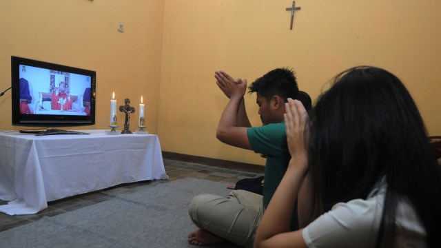 Keluarga umat Katolik mengikuti Misa Minggu Palma melalui media daring di Sawit, Boyolali, Jawa Tengah, Sabtu (4/4). Foto: ANTARA FOTO/Aloysius Jarot Nugroho
