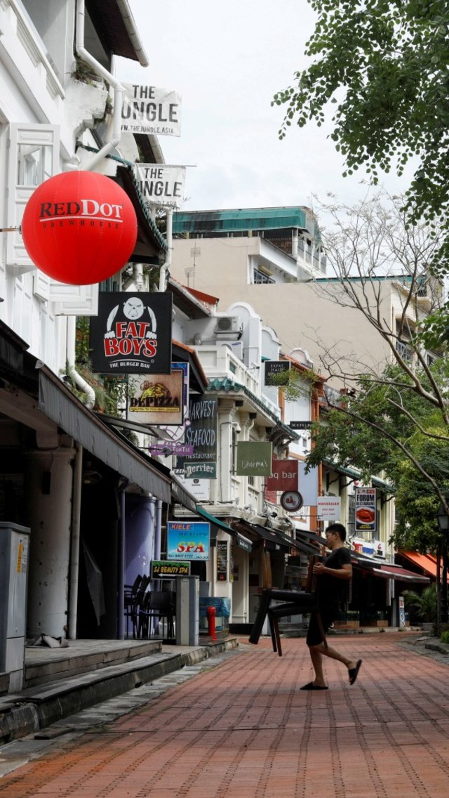 Pekerja membawa kursi pada hari pertama work from home untuk mengekang wabah virus corona (COVID-19) di Boat Quay, Singapura, Selasa (7/4). Foto: REUTERS/Edgar Su