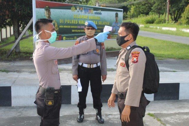 Anggota Polres Halmahera Selatan saat melakukan cek suhu tubuh. Foto: Isitmewa