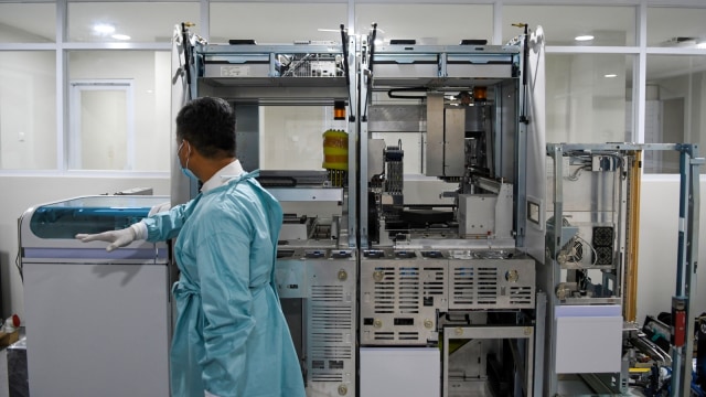 Seorang dokter berjalan di dekat alat tes swab virus Corona berupa Polymerase Chain Reaction diagnostic kit (PCR) di Laboratorium Rumah Sakit Pertamina Jaya. Foto: ANTARA FOTO/M Risyal Hidayat