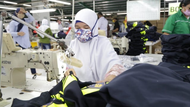 Para buruh korban PHK membuat masker untuk penanganan virus corona, di Kawasan Berikat Nusantara (KBN) Cilincing, Jakarta, Selasa (7/4). Foto: Dok. Biro Humas Kemnaker