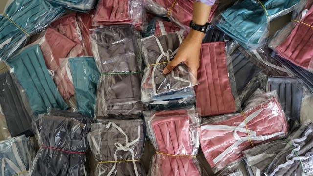 Warga memilah masker berbahan kain (7/4/2020). Foto: ANTARA FOTO/Makna Zaezar