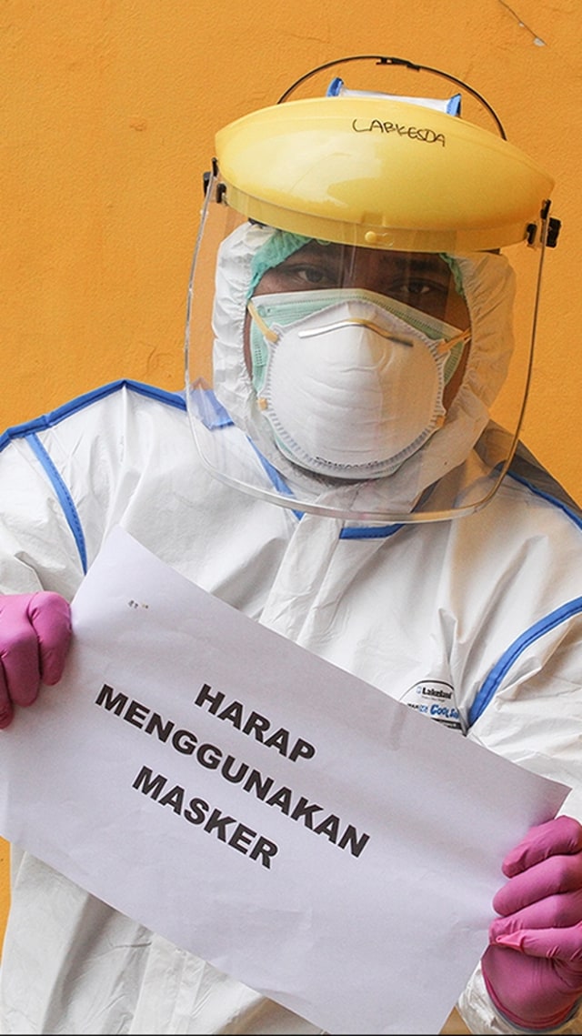 Petugas medis menunjukkan imbauan untuk masyarakat terkait virus corona seusai melaksanakan SWAB Test di Cimanggis, Depok, Jawa Barat, Minggu (8/4). Foto: ANTARA FOTO/Asprilla Dwi Adha