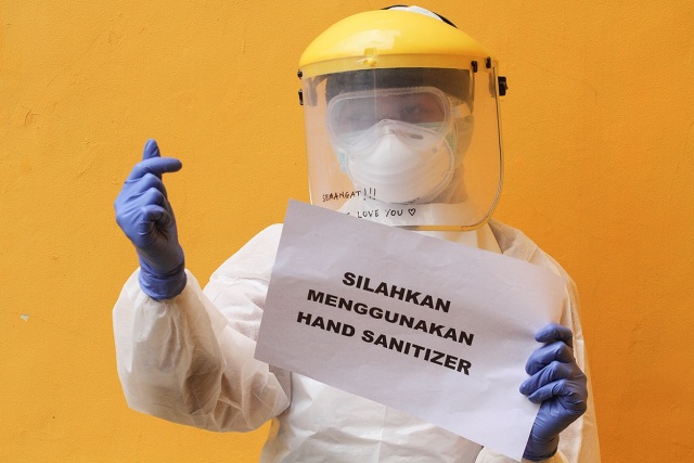 Petugas medis menunjukkan imbauan untuk masyarakat terkait virus corona seusai melaksanakan SWAB Test di Cimanggis, Depok, Jawa Barat, Minggu (8/4). Foto: ANTARA FOTO/Asprilla Dwi Adha