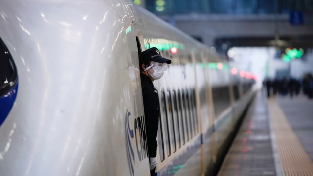 Petugas berdiri di pintu kereta cepat yang merupakan kereta pertama yang meninggalkan Stasiun Kereta Api Hankou Wuhan, Hubei, China, Rabu (8/4). Foto: REUTERS / Aly Song